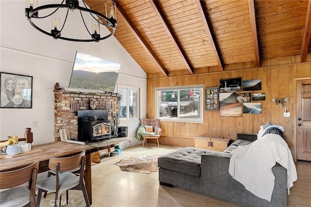 living room with wooden ceiling, a wood stove, wooden walls, and beamed ceiling