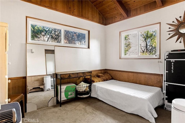 bedroom featuring lofted ceiling with beams, wood ceiling, wood walls, and carpet flooring