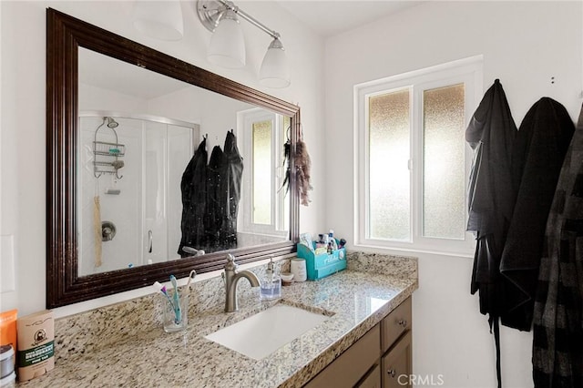 bathroom with a shower with door and vanity