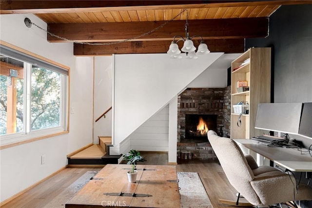 office space with wooden ceiling, a fireplace, a chandelier, beam ceiling, and light hardwood / wood-style flooring