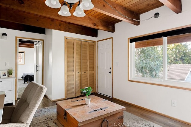 living room with beam ceiling, light hardwood / wood-style flooring, a notable chandelier, and wooden ceiling