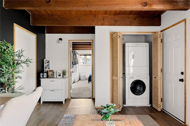 clothes washing area featuring stacked washing maching and dryer, dark hardwood / wood-style flooring, and wooden ceiling