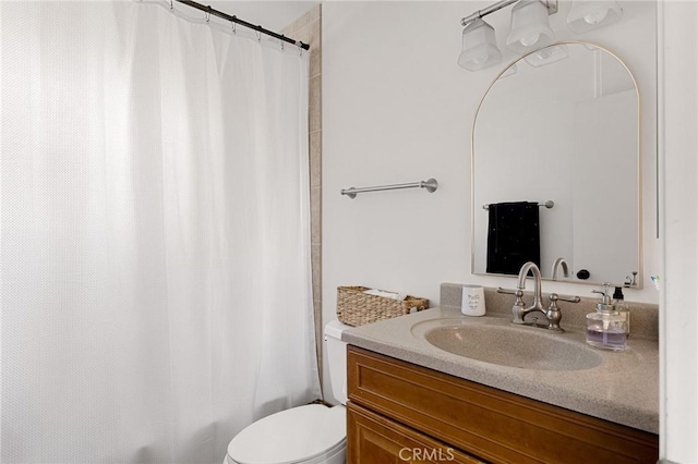 bathroom with toilet, a shower with shower curtain, and vanity