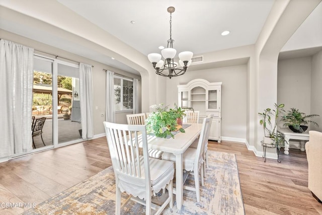 dining space featuring a chandelier and light hardwood / wood-style floors