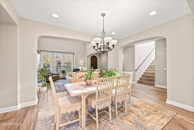 dining area with an inviting chandelier and light hardwood / wood-style flooring