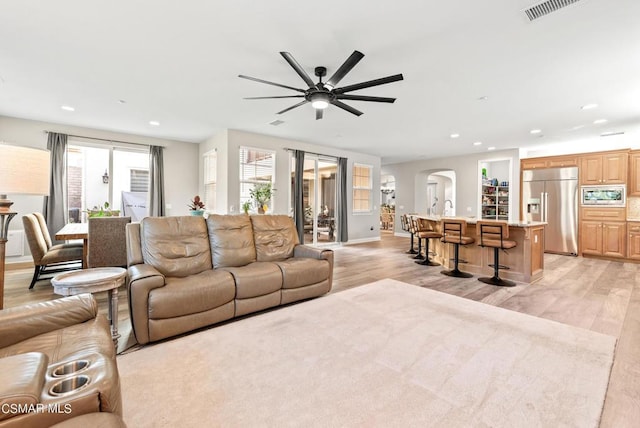 living room featuring ceiling fan and light wood-type flooring