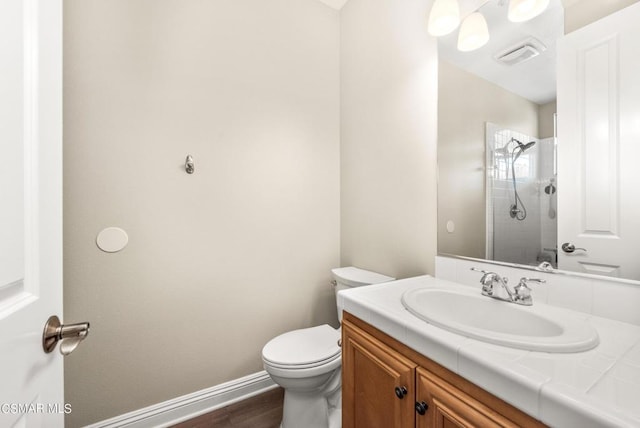 bathroom featuring vanity, hardwood / wood-style flooring, toilet, and walk in shower