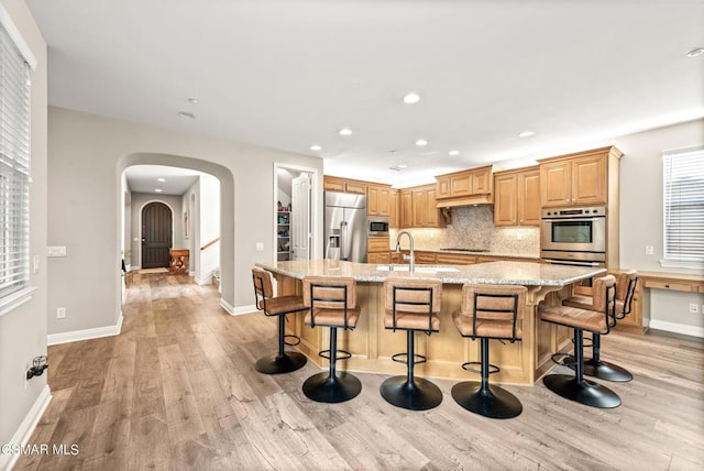 kitchen featuring built in appliances, a large island, and a breakfast bar area