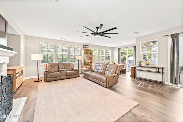 living room with ceiling fan and light wood-type flooring