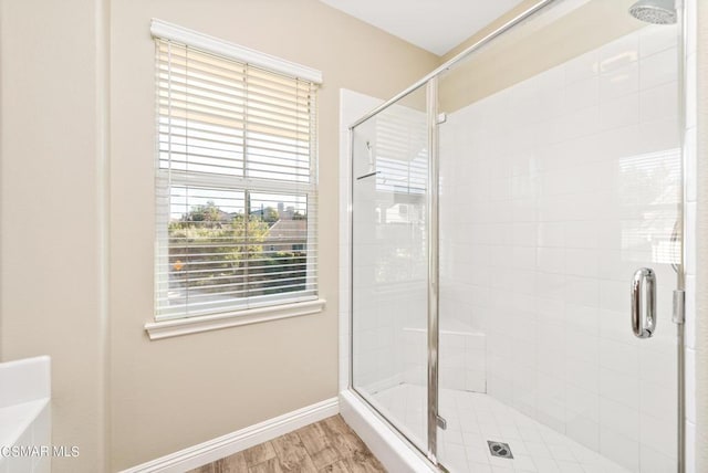 bathroom featuring wood-type flooring and an enclosed shower