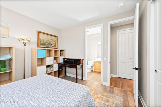 bedroom featuring ensuite bath and light hardwood / wood-style flooring