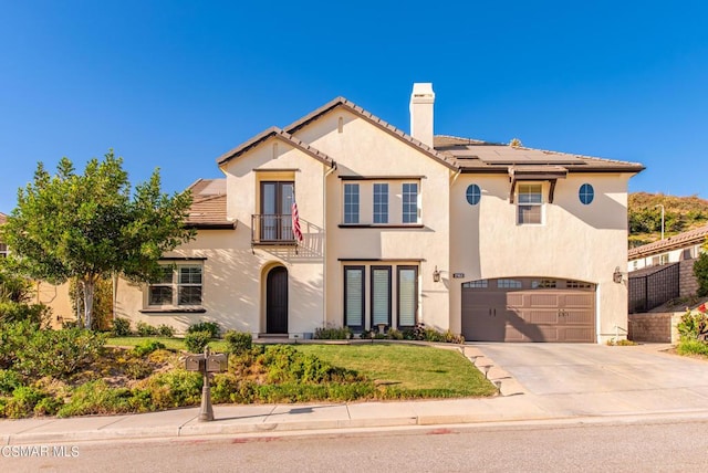 mediterranean / spanish-style house featuring a garage and solar panels