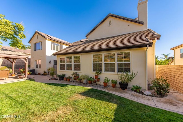 rear view of property featuring a yard and a patio area