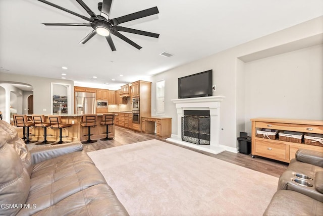 living room featuring ceiling fan and light hardwood / wood-style flooring