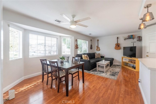 dining space with hardwood / wood-style flooring, ceiling fan, and a wealth of natural light