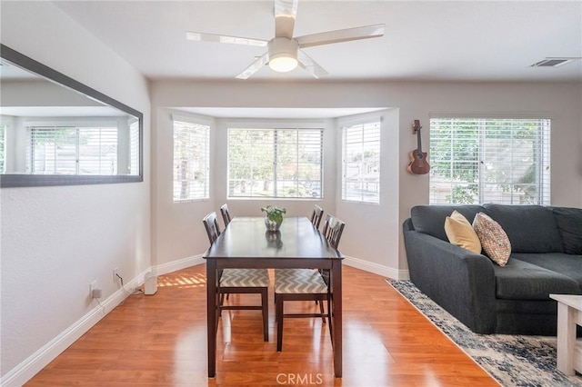 dining space with light hardwood / wood-style flooring and ceiling fan