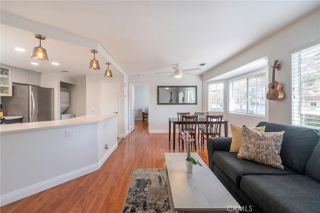 living room with ceiling fan, a healthy amount of sunlight, and light hardwood / wood-style floors