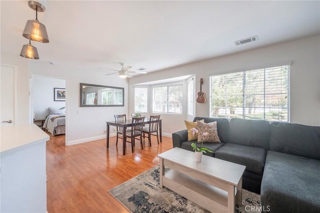 living room featuring ceiling fan and light hardwood / wood-style flooring