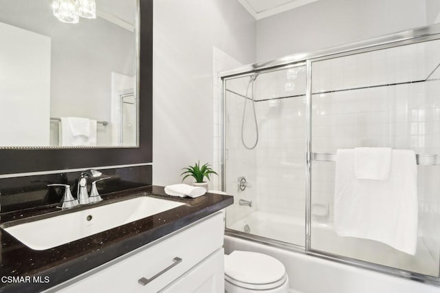 full bathroom with toilet, enclosed tub / shower combo, and vanity