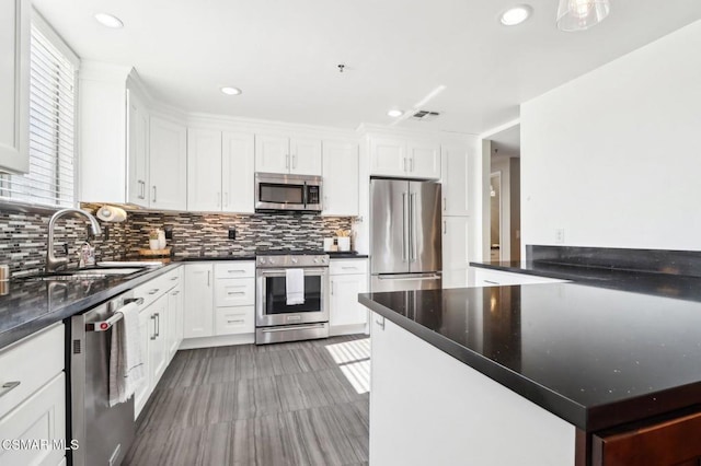 kitchen featuring tile patterned floors, decorative backsplash, sink, white cabinetry, and stainless steel appliances