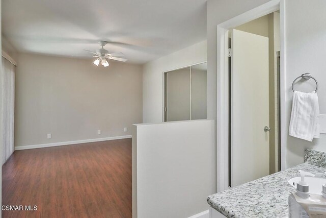 interior space with ceiling fan and dark hardwood / wood-style flooring