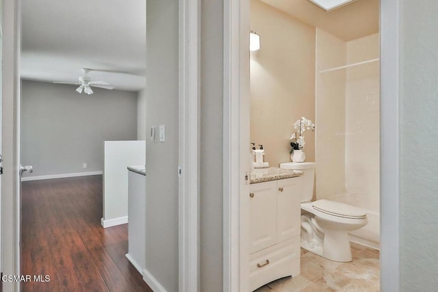 bathroom with toilet, ceiling fan, wood-type flooring, walk in shower, and vanity