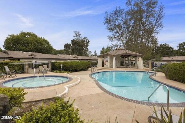 view of swimming pool featuring a patio area and a hot tub