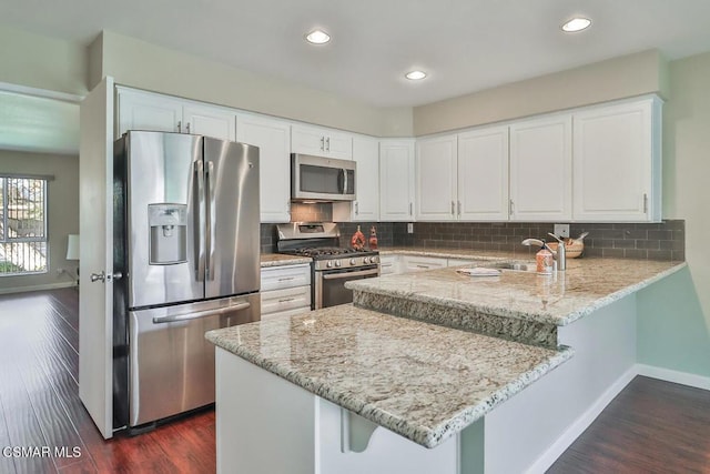 kitchen featuring white cabinets, appliances with stainless steel finishes, and kitchen peninsula