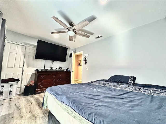 bedroom with ceiling fan, a closet, and light hardwood / wood-style flooring