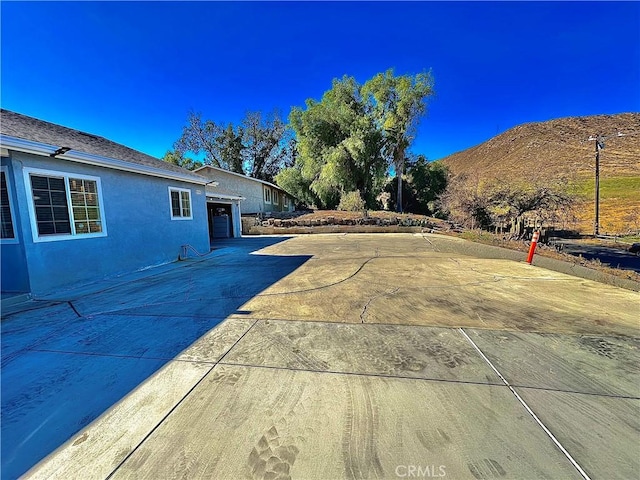 view of patio / terrace with a mountain view and a garage