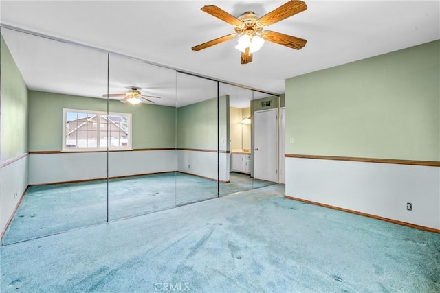 unfurnished room with ceiling fan and carpet