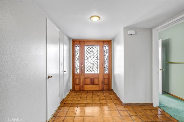 entrance foyer featuring baseboards and light tile patterned floors