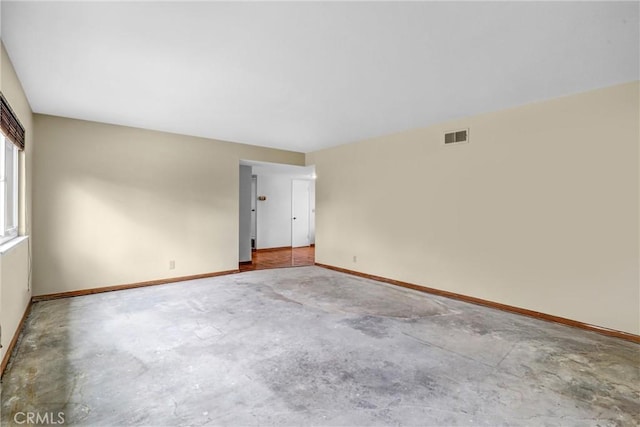 unfurnished room featuring unfinished concrete flooring, visible vents, and baseboards