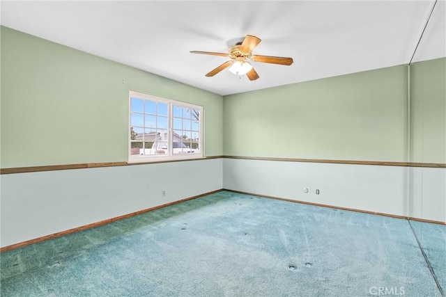 spare room with carpet flooring, ceiling fan, and baseboards