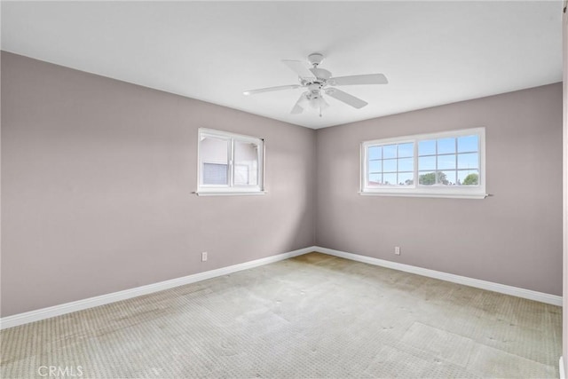 carpeted empty room featuring ceiling fan and baseboards