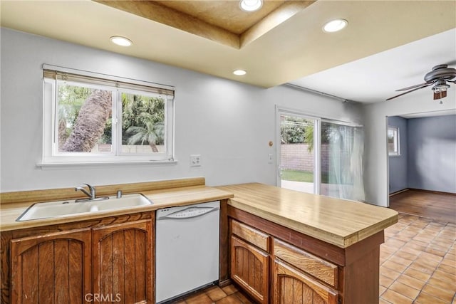 kitchen featuring a peninsula, white dishwasher, light countertops, a sink, and recessed lighting