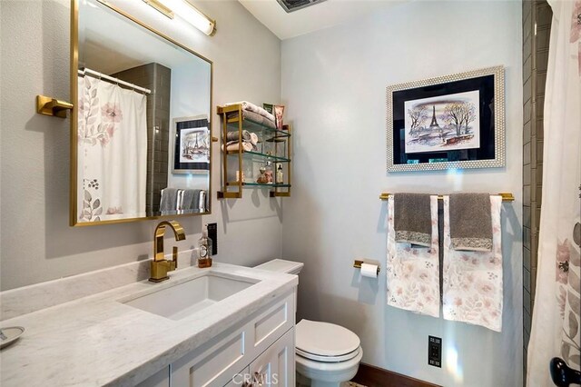 bathroom featuring toilet, vanity, and a shower with shower curtain