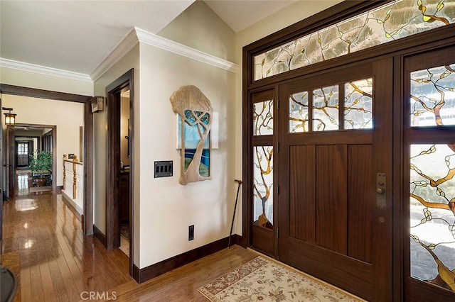 foyer entrance with crown molding and hardwood / wood-style floors