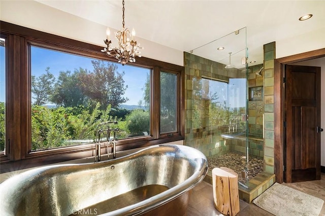 bathroom featuring a notable chandelier, a shower with shower door, and sink