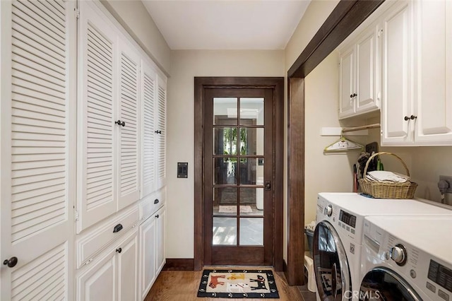 laundry area featuring dark hardwood / wood-style flooring, washing machine and clothes dryer, and cabinets