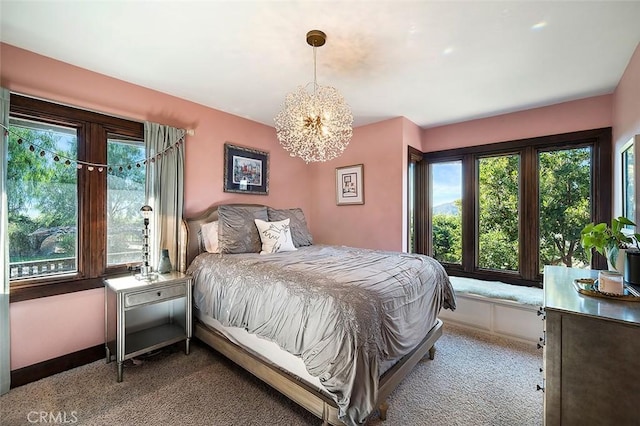 bedroom featuring an inviting chandelier and light colored carpet