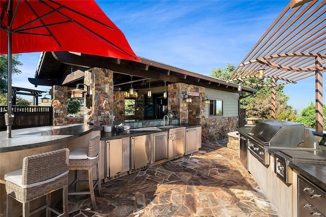 view of patio featuring grilling area, a pergola, an outdoor kitchen, and sink