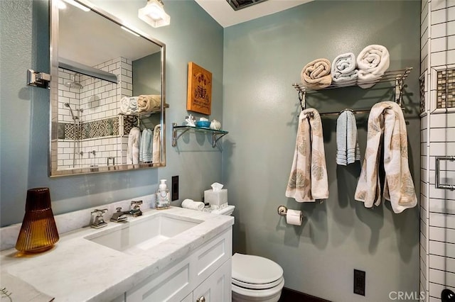 bathroom with toilet, an enclosed shower, and vanity