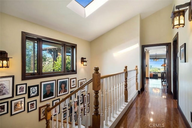 corridor with dark hardwood / wood-style floors, a skylight, and a notable chandelier