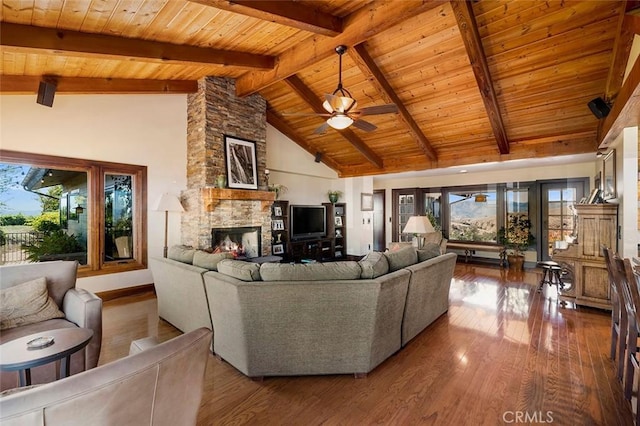 living room featuring wood ceiling, high vaulted ceiling, beamed ceiling, and a fireplace