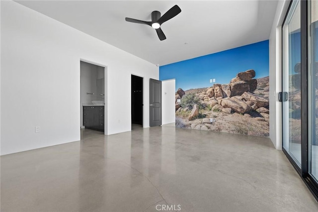 spare room featuring ceiling fan and concrete floors