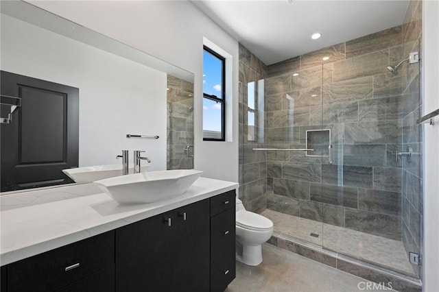 bathroom featuring toilet, vanity, an enclosed shower, and concrete floors