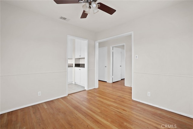 empty room with light hardwood / wood-style floors and ceiling fan