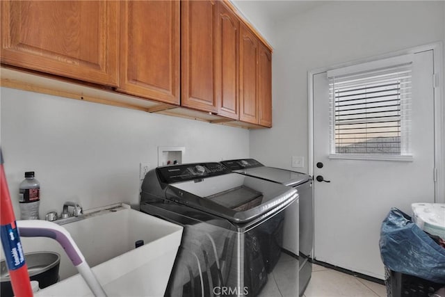 laundry room featuring cabinets, light tile patterned floors, independent washer and dryer, and sink