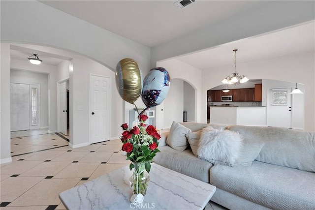 tiled living room featuring a notable chandelier